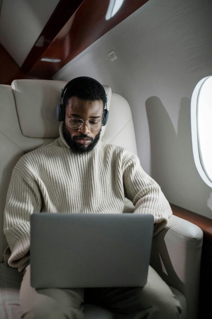 pexels-photo-6700148-6700148 A focused businessman using a laptop and headphones while traveling on a private jet.